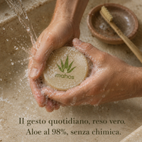 Sapone artigianale MAHOS all'aloe vera insaponato tra le mani, con spazzolino in bambù